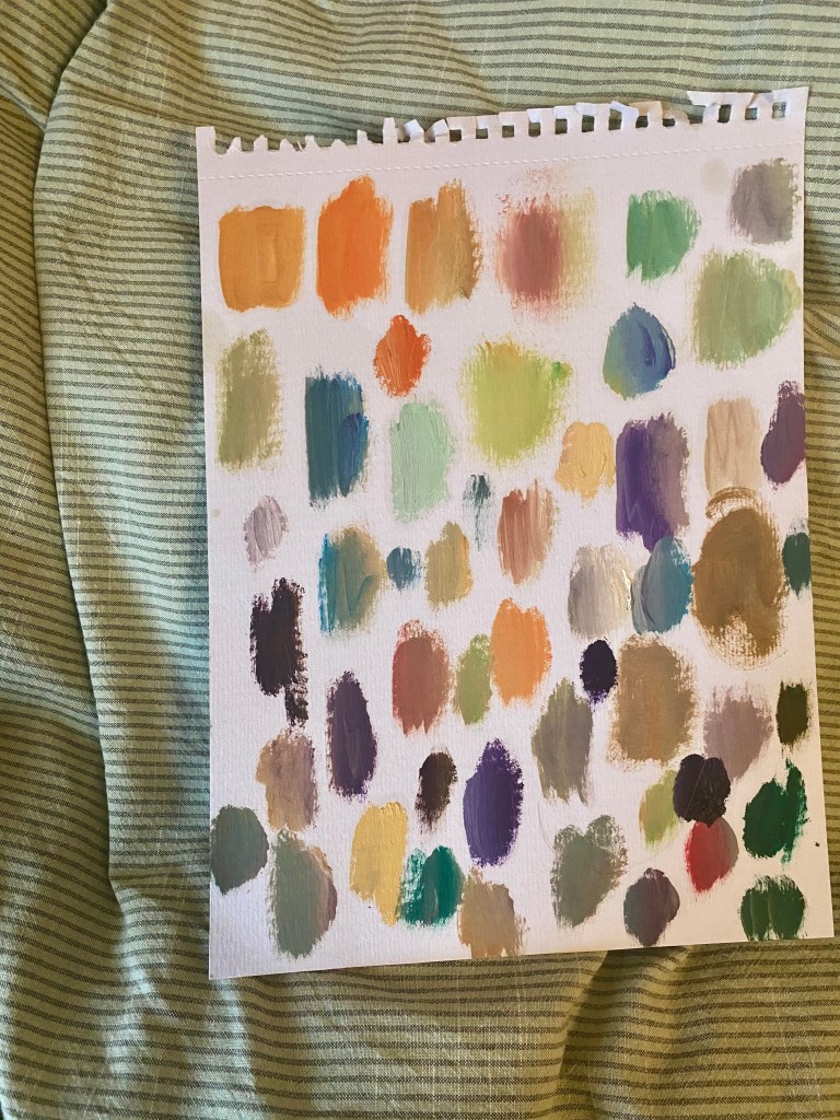 a white piece of paper with colour swatches painted on