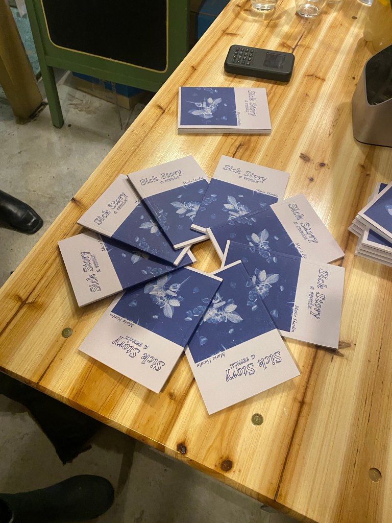 Pamphlets titled Sick Story spread into a spiral on a wooden table